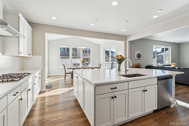 kitchen featuring appliances with stainless steel finishes, sink, white cabinets, backsplash, and wall chimney exhaust hood