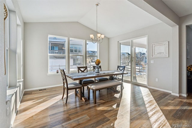 dining space with hardwood / wood-style flooring, a healthy amount of sunlight, and a chandelier