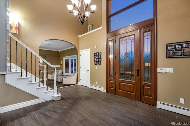 entryway featuring arched walkways, a baseboard radiator, baseboards, and wood finished floors