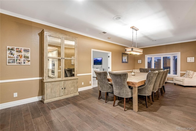 dining area with crown molding and dark wood-style flooring