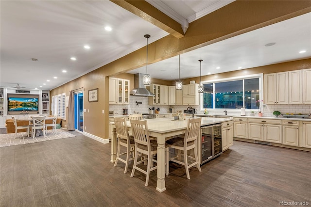 dining space featuring beverage cooler, dark wood finished floors, ornamental molding, and recessed lighting