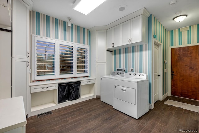 laundry room with dark wood finished floors, visible vents, wallpapered walls, and washer and dryer