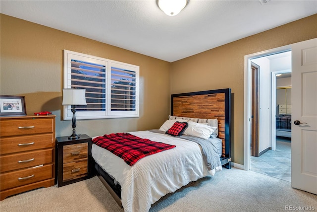 bedroom with baseboards and light colored carpet