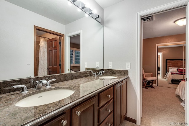 bathroom with a sink, ensuite bathroom, and double vanity