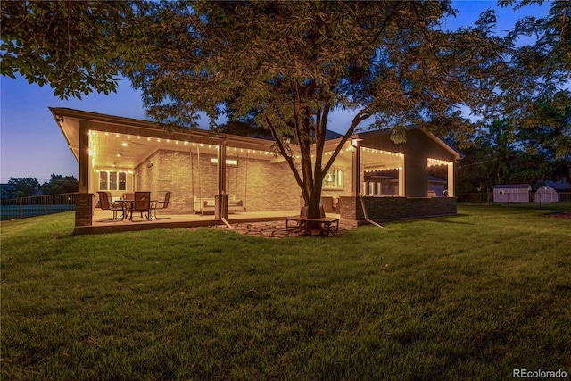 back of house featuring a lawn, a patio area, and fence