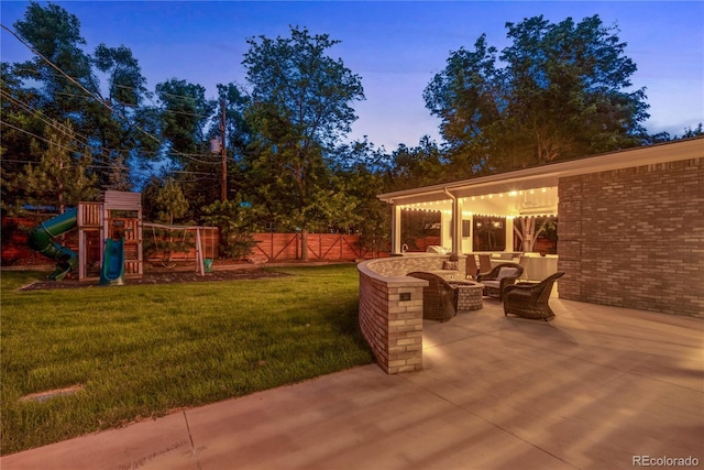 patio terrace at dusk featuring a lawn, a playground, fence, and an outdoor hangout area