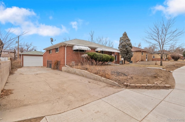 view of front of property with fence, driveway, an outdoor structure, a garage, and brick siding