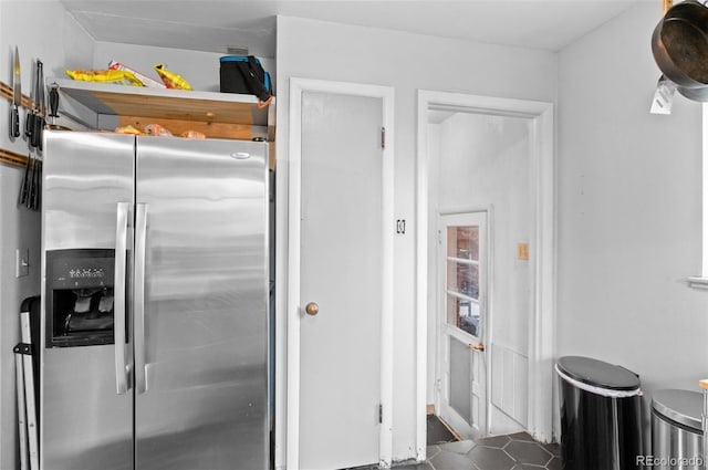 kitchen featuring tile patterned flooring and stainless steel refrigerator with ice dispenser