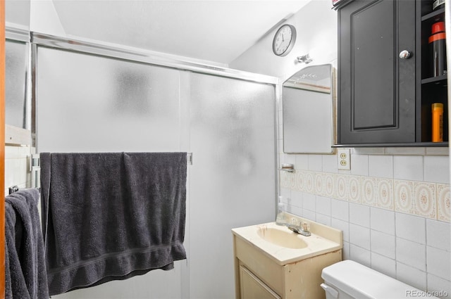 full bathroom with vanity, tile walls, toilet, and an enclosed shower