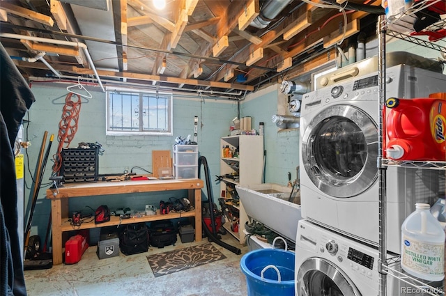 washroom featuring stacked washer / dryer, laundry area, and a sink