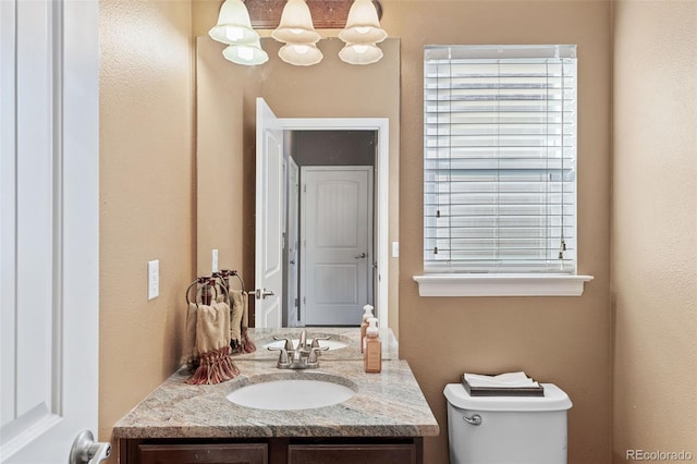 20466 Willowbend Ln, Parker, CO 80138 - half bathroom featuring vanity, a textured wall, and toilet