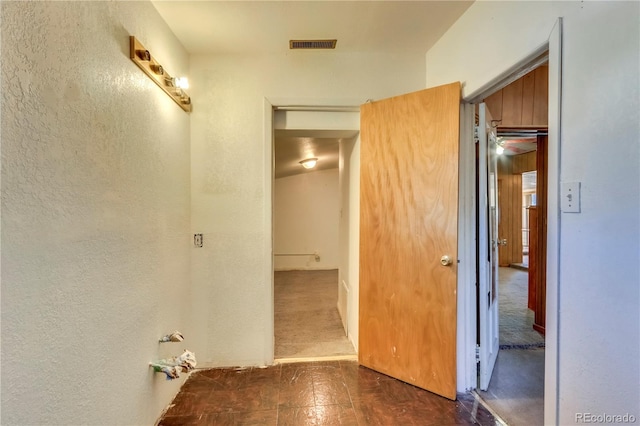 hallway featuring dark carpet