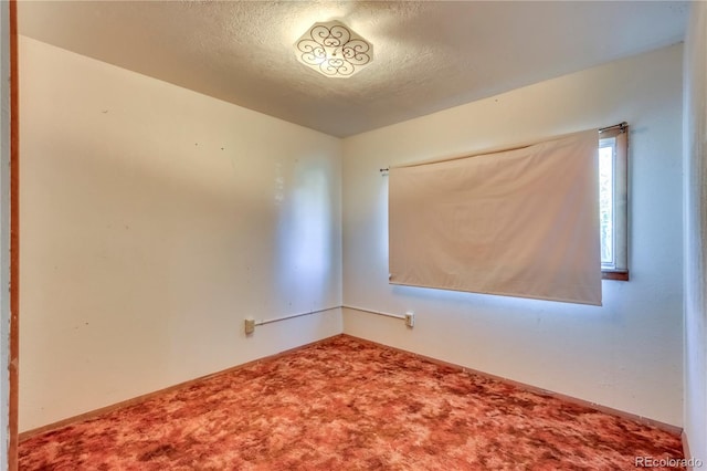 carpeted spare room with a textured ceiling