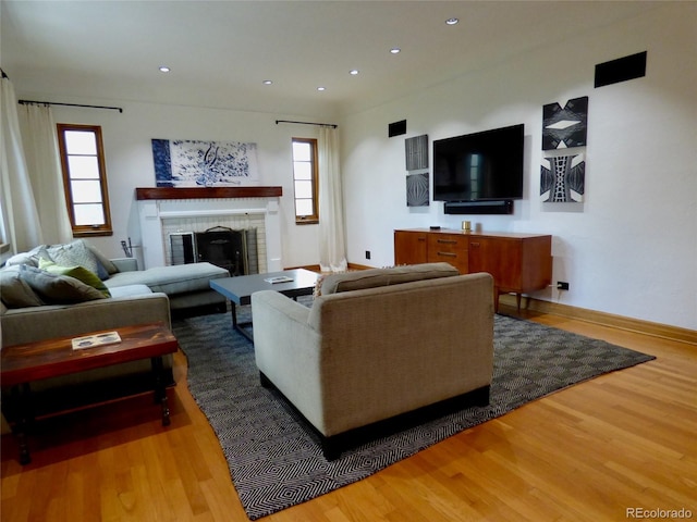 living area with recessed lighting, baseboards, wood finished floors, and a fireplace