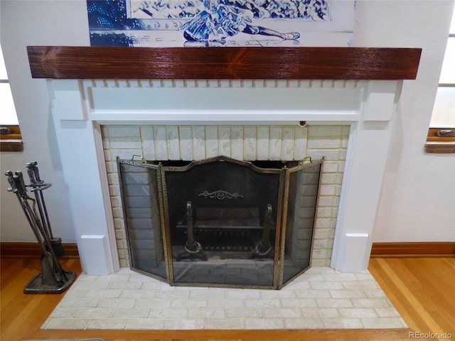 room details with baseboards, a fireplace, and wood finished floors