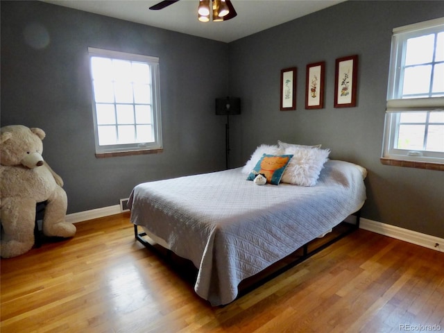 bedroom featuring baseboards, ceiling fan, and wood finished floors