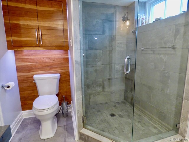 full bathroom with toilet, tile patterned flooring, and a stall shower