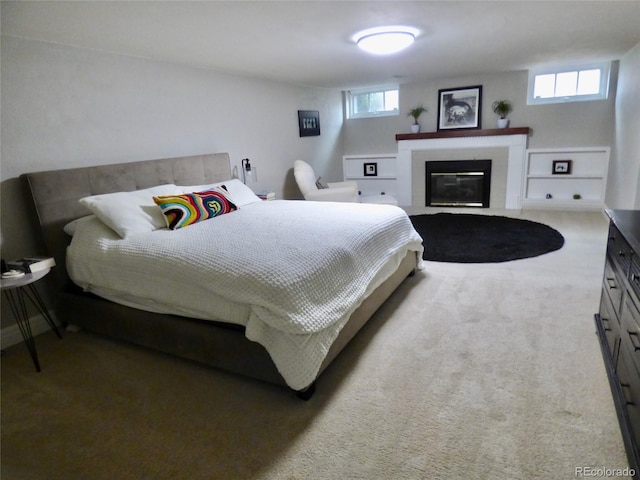 bedroom featuring a fireplace with flush hearth, carpet floors, and multiple windows