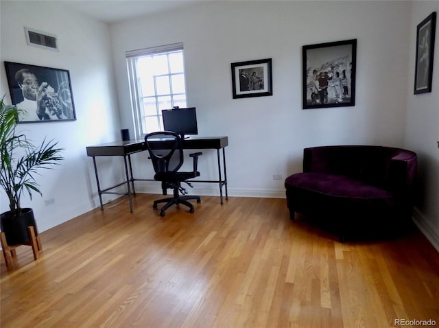 home office featuring baseboards, visible vents, and light wood-style floors