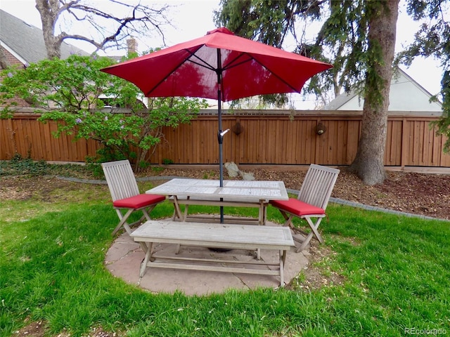 view of yard with a fenced backyard, outdoor dining space, and a patio area