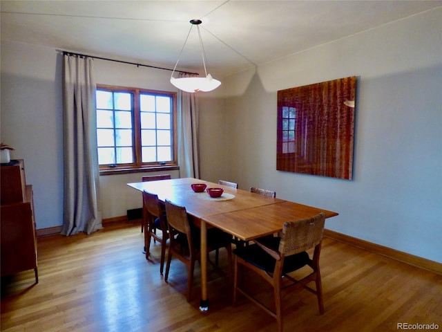 dining space with baseboards and light wood-style floors