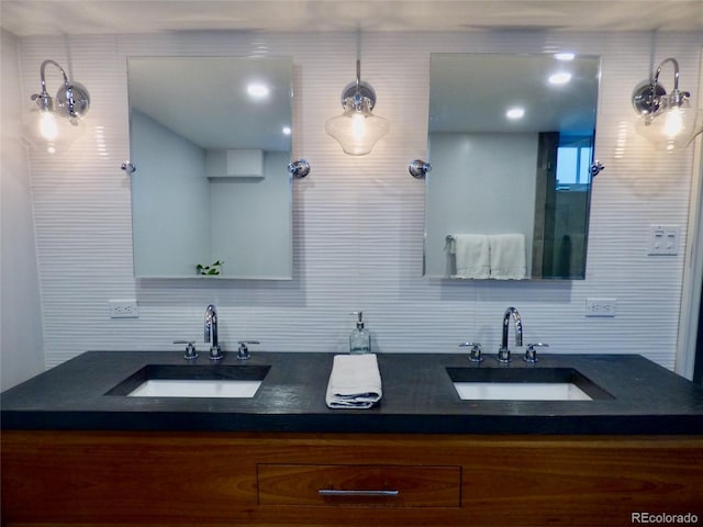full bath featuring double vanity, a sink, and tasteful backsplash