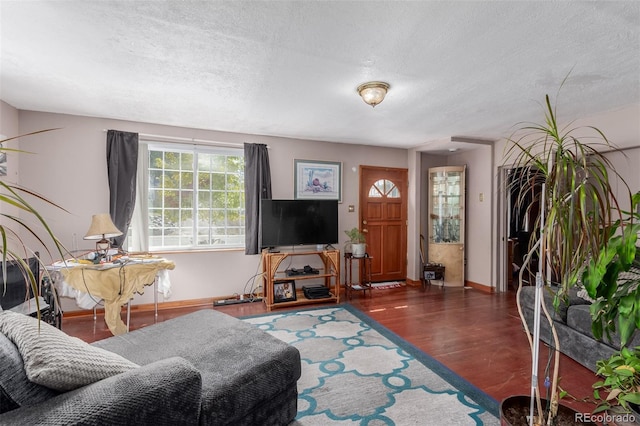 living room with a textured ceiling and dark wood-type flooring