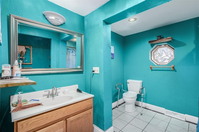 bathroom featuring tile patterned flooring, vanity, and toilet