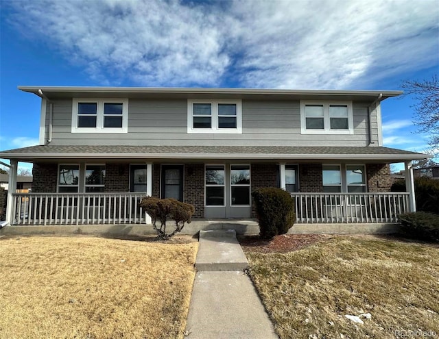 front of property with covered porch and a front lawn