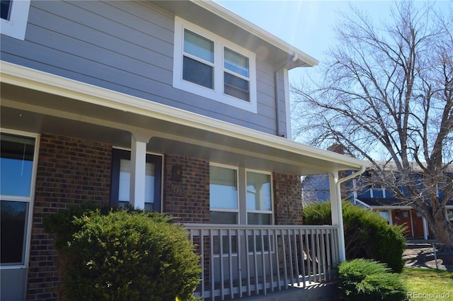 exterior space featuring brick siding and a porch