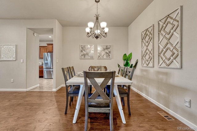 dining area featuring dark hardwood / wood-style flooring and a notable chandelier