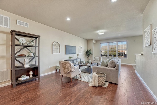 living room with dark wood-type flooring and a textured ceiling