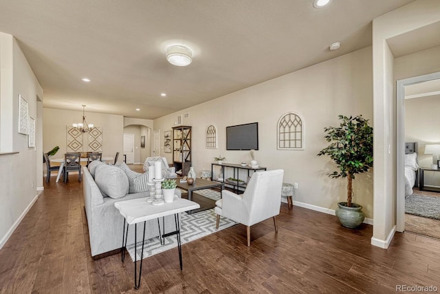 living room featuring a chandelier and dark hardwood / wood-style floors