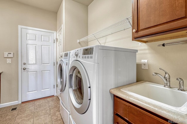 laundry area featuring cabinets, sink, and independent washer and dryer