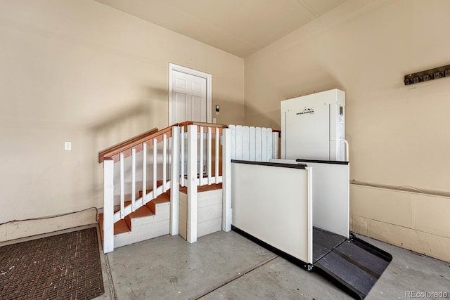 staircase featuring concrete floors