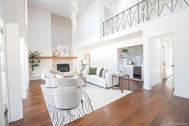 living room featuring a large fireplace, dark hardwood / wood-style floors, and a towering ceiling