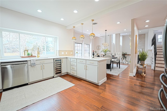 kitchen featuring white cabinets, dishwasher, kitchen peninsula, and wine cooler