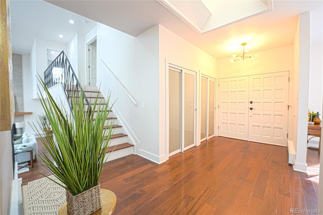 foyer entrance featuring dark wood-type flooring and a notable chandelier