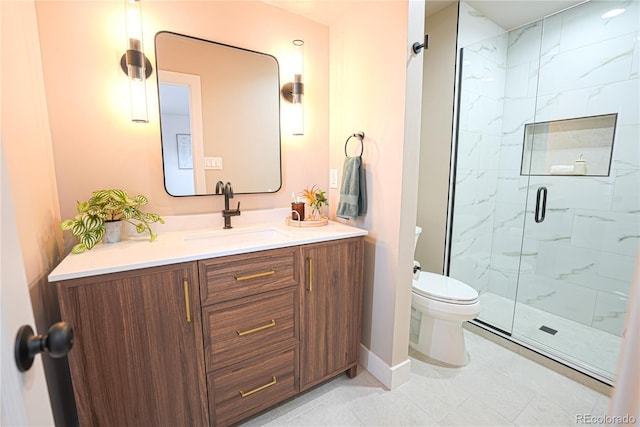 bathroom with vanity, a shower with door, and toilet