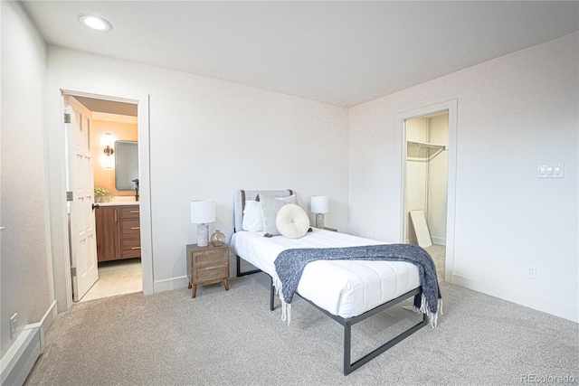 carpeted bedroom featuring connected bathroom and a spacious closet