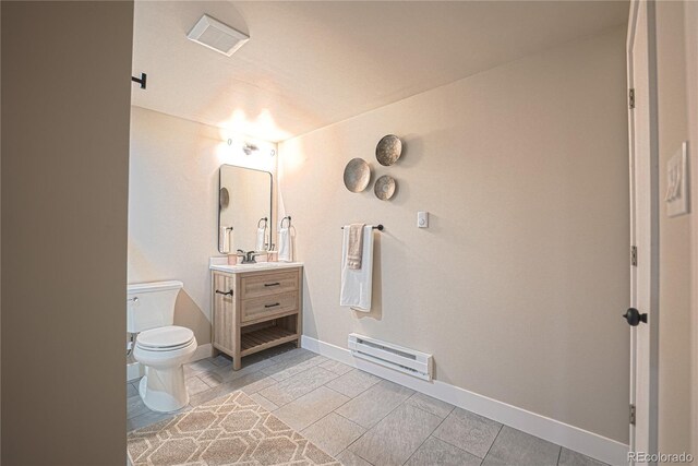 bathroom featuring toilet, vanity, and a baseboard radiator