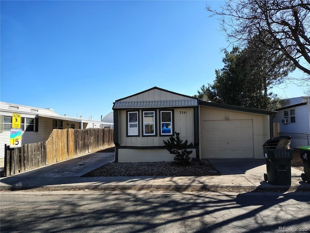 view of front of home featuring board and batten siding, fence, driveway, and an attached garage