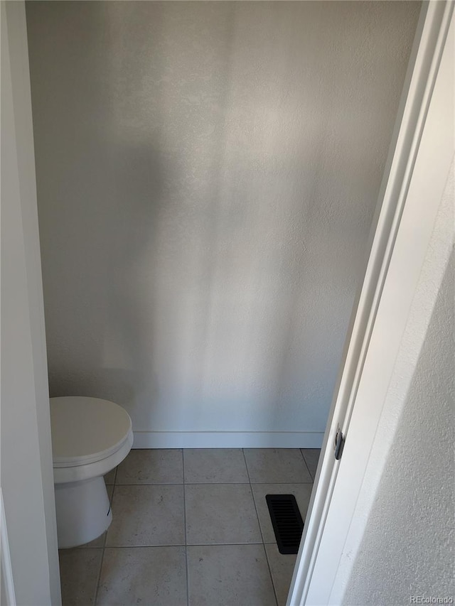 bathroom with baseboards, toilet, visible vents, and tile patterned floors