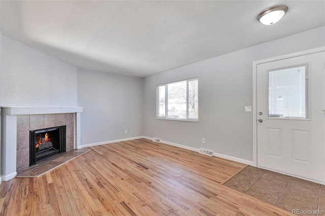 unfurnished living room with hardwood / wood-style floors and a fireplace