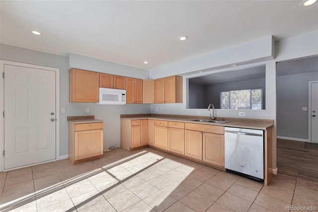 kitchen with dishwasher, sink, light tile patterned flooring, and light brown cabinets