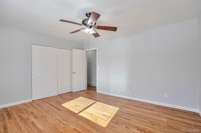 unfurnished bedroom featuring a closet, ceiling fan, and light wood-type flooring