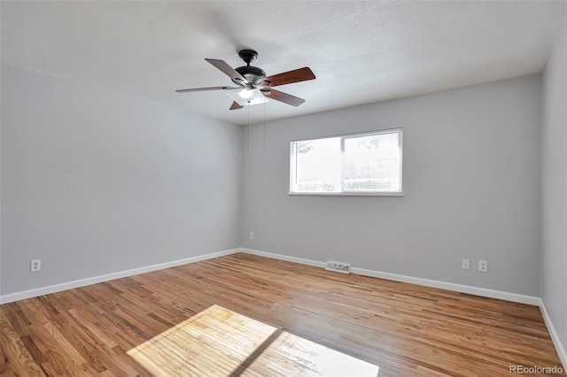 spare room with ceiling fan, a textured ceiling, and light wood-type flooring