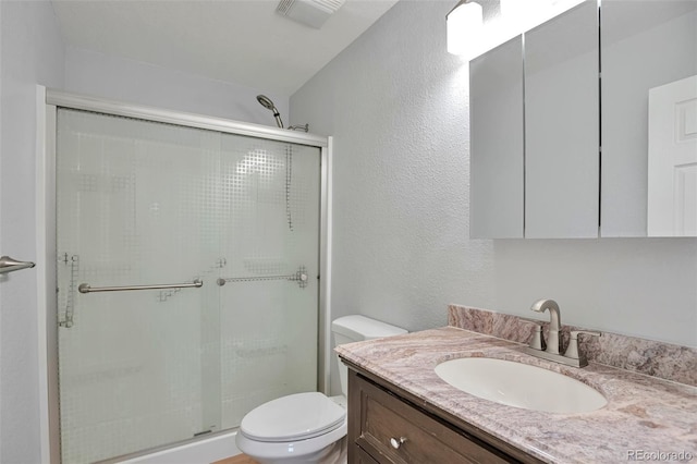 bathroom featuring walk in shower, vanity, and toilet