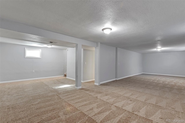 basement featuring light carpet and a textured ceiling