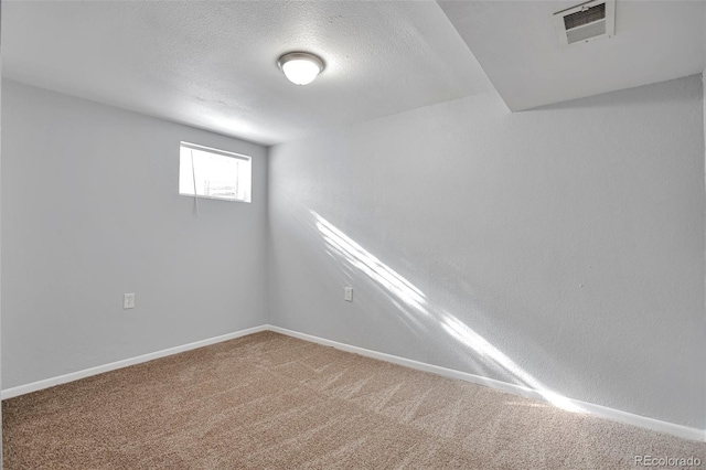 basement featuring carpet flooring and a textured ceiling